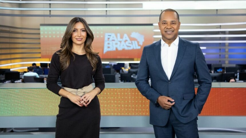 Paloma Poeta e Luiz Fara Monteiro, sorridentes em foto posada no cenário do Fala Brasil