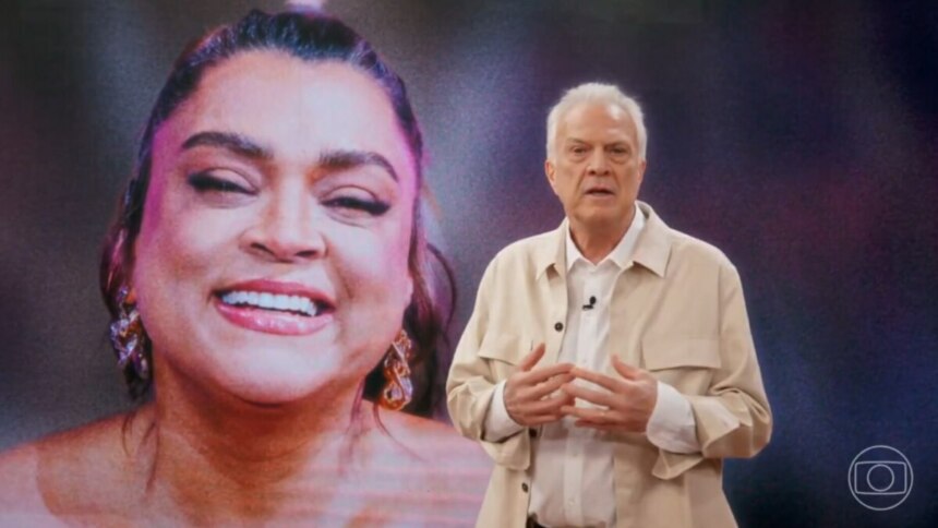 Pedro Bial em frente ao telão, com foto da cantora, em trecho do Conversa com Bial homenagem a Preta Gil