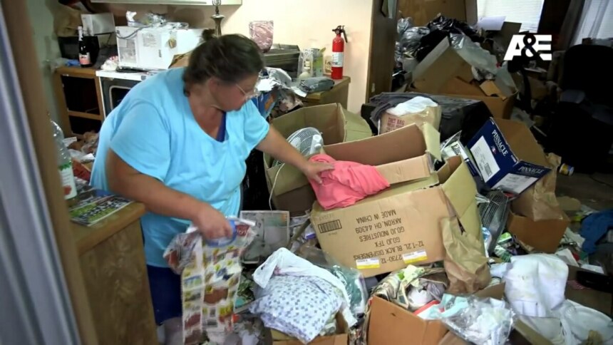 Judy segura objetos enquanto caminha pelo lixo da casa