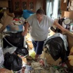 Judy anda em meio ao lixo na cozinha de sua casa em cena de Acumuladores