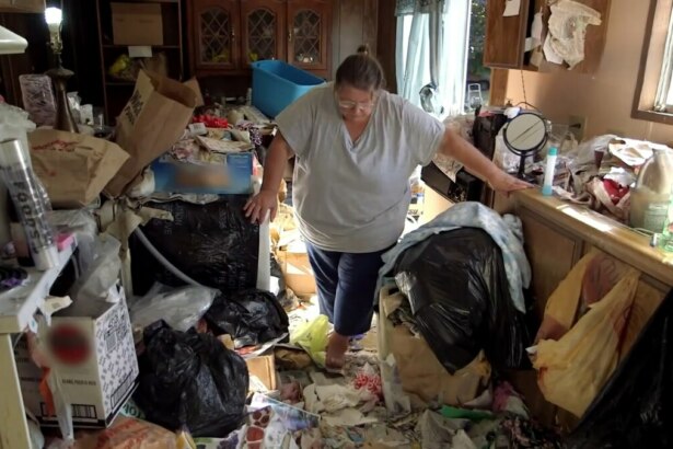 Judy anda em meio ao lixo na cozinha de sua casa em cena de Acumuladores
