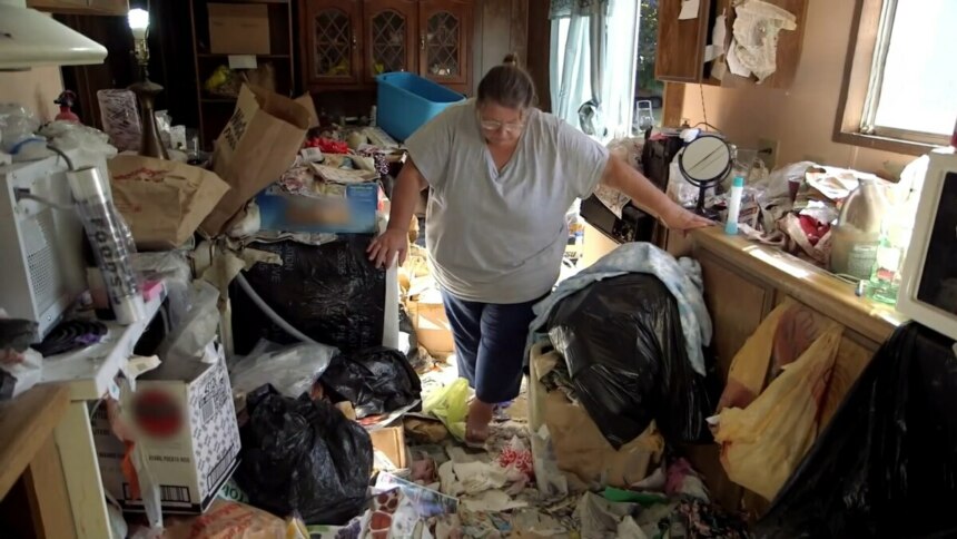 Judy anda em meio ao lixo na cozinha de sua casa em cena de Acumuladores