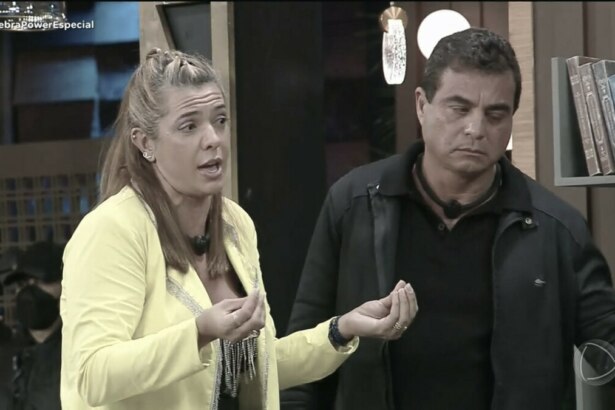 Adriana ao lado de Dhomini gesticulando, nervosa, tentando explicar a mentira no Power Couple Brasil 7