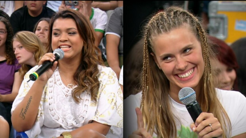 Preta Gil segura o microfone do Altas Horas e sorrir ao falar junto com Carolina Dieckmmann sobre amizade. As duas vestem branco e estão sentadas