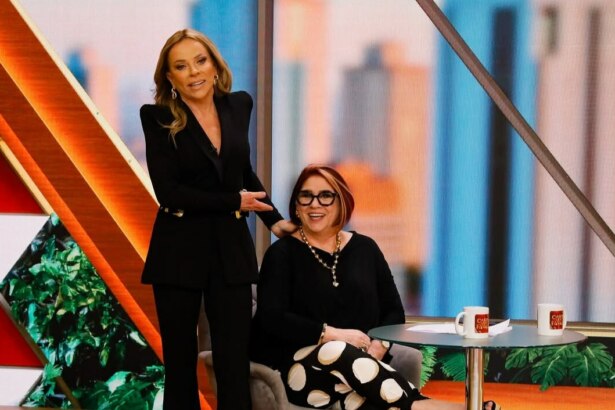 Cristina Rocha em pé aponta para doutora Anahy que está sentada no cenário do Casos de Família toda sorridente