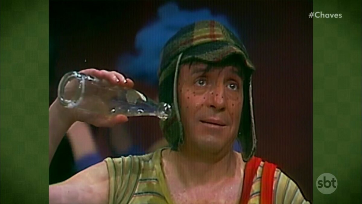 Chaves paralisado com uma garrafa de vidro próximo a orelha
