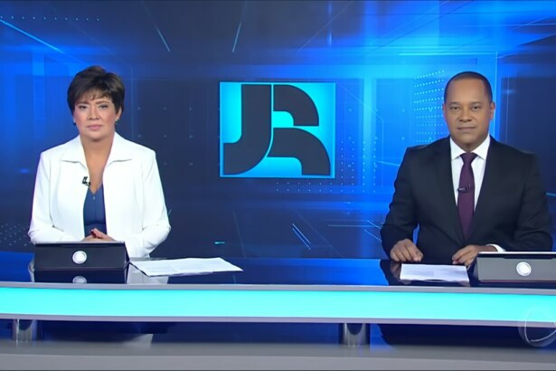 Christina Lemos e Luiz Fara Monteiro sentados na bancada do Jornal da Record