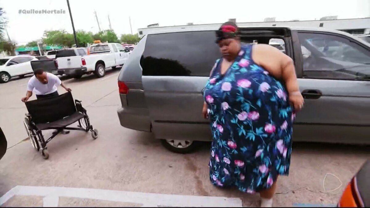 Mercedes, extremamente obesa, sai de um carro e tenta caminhar em cena de Quilos Mortais