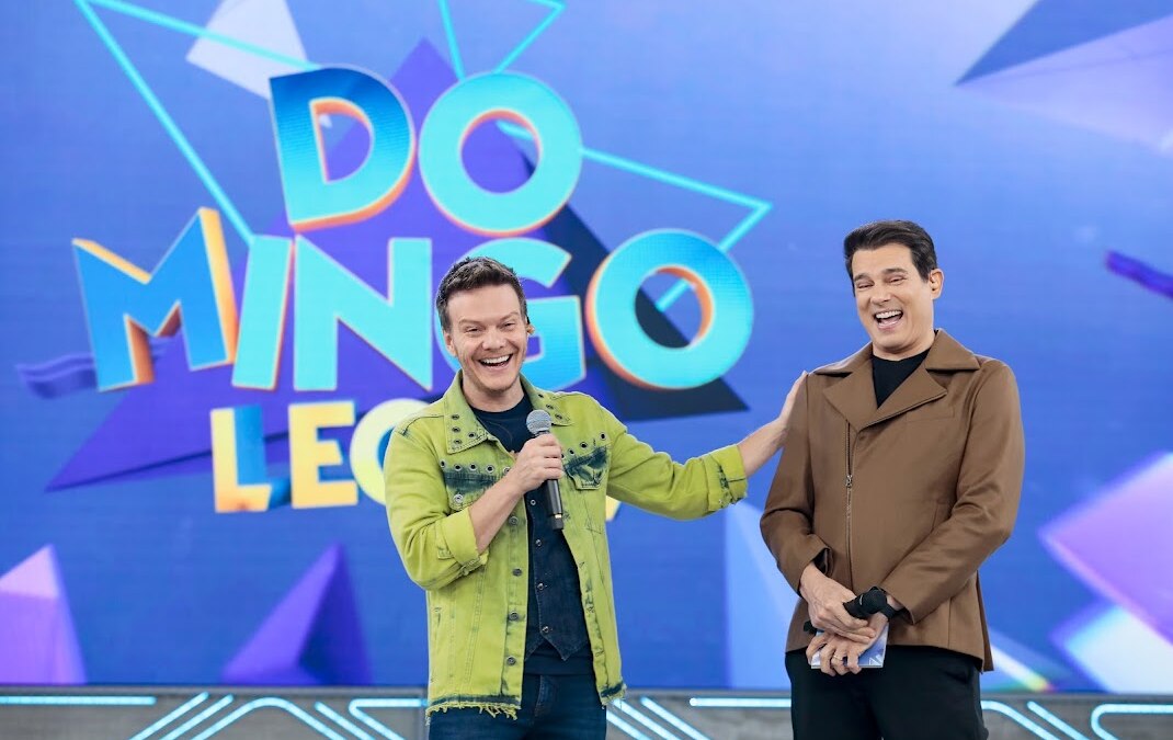 Michel Teló toca no ombro de Celso Portiolli enquanto so dois caem na risada no Domingo Legal