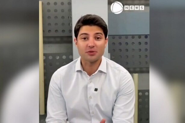 Rafael Algarte de camisa branca no cenário da Record News. O apresentador está sorridente