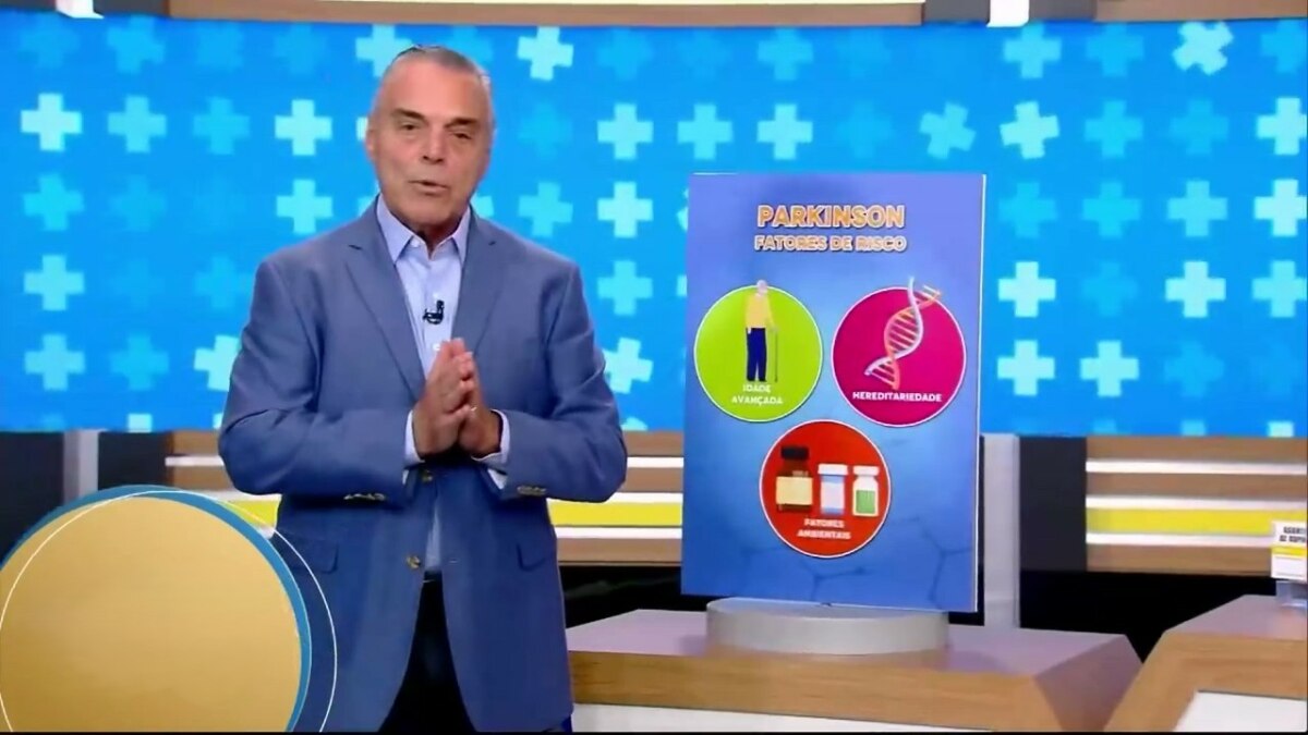 Dr. Antônio Sproesser ao lado de uma placa de Doença de Parkinson no palco do Hoje em Dia