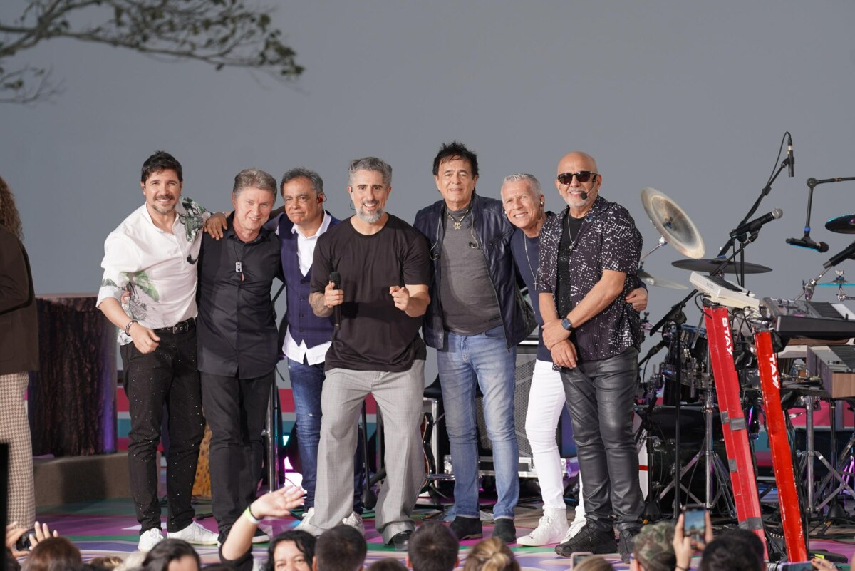 Mion posa com o grupo Roupa Nova no centro do palco do Caldeirão. No fundo o céu já escurecendo em Foz do Iguaçu