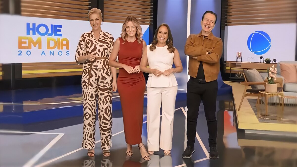 Apresentadores Celso Zucatelli, Ana Hickmann, Renata Alves e Ticiane Pinheiro em estúdio decorado para a celebração dos 20 anos do *Hoje em Dia* (Record), com telão exibindo a marca comemorativa, sofá azul, mesa com flores e painel de madeira ao fundo