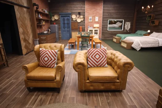 Interior rústico e aconchegante do Paiol de A Fazenda, com áreas de convivência, jantar, cozinha e camas decoradas