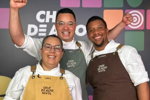 A imagem mostra três finalistas do reality show "Chef de Alto Nível". Da esquerda para a direita, Arika, Lira e Mamede. Os três estão sorrindo e comemorando, com os punhos erguidos. Todos vestem dólmãs brancos e aventais de chef com a inscrição "CHEF DE ALTO NÍVEL". O painel ao fundo repete o nome do programa.