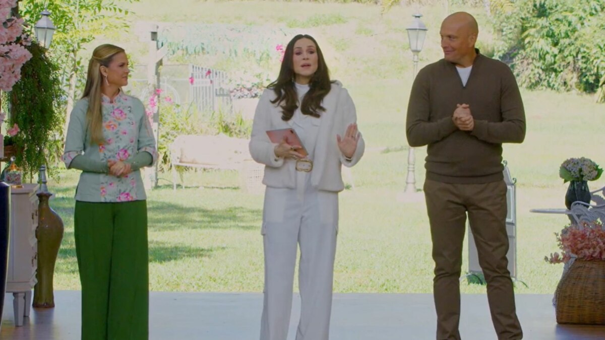 A apresentadora e os jurados do programa 'Bake Off Brasil' estão em um cenário com muita vegetação. Da esquerda para a direita, estão Beca Milano, de blusa verde estampada e calça verde, Nadja Haddad de casaco e calça brancos, e Giuseppe Gerundino de suéter marrom.