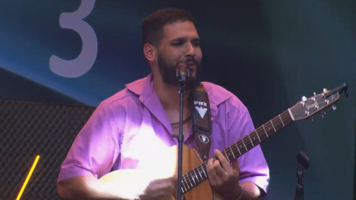 Brenno Casagrande tocando violão, em trecho fase de grupos na Prova do Jingle no Estrela da Casa