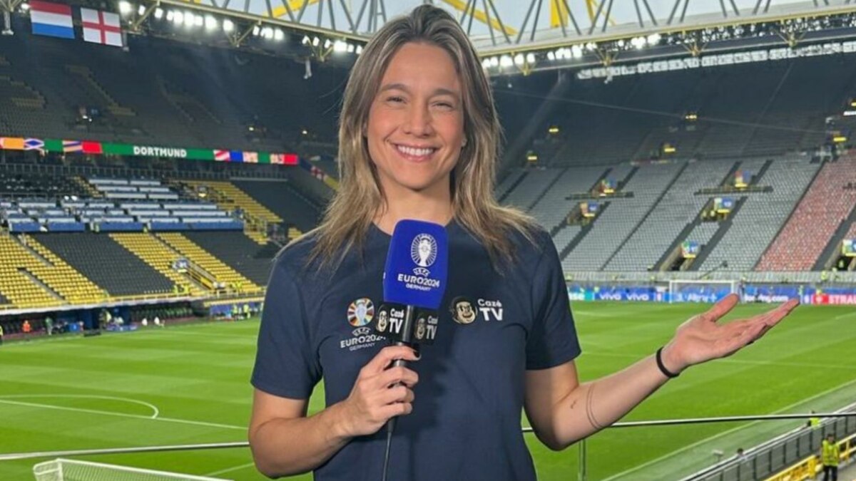 A apresentadora Fernanda Gentil sorri para a câmera, segurando um microfone com o logo da 'CazéTV'. Ela está em um estádio de futebol, e o nome do arquivo a associa ao canal de TV.