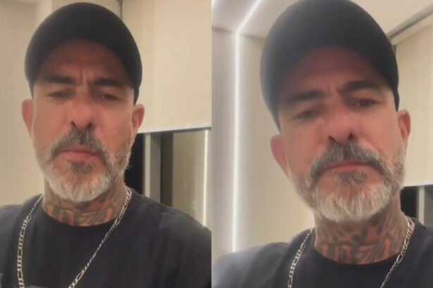 Montagem em tela dividida, com duas imagens iguais do chef Henrique Fogaça. Ele usa um boné preto, uma camiseta preta e exibe tatuagens no pescoço. Ele tem barba e bigode grisalhos e olha para a câmera com uma expressão séria, falando sobre o MasterChef Celebridades