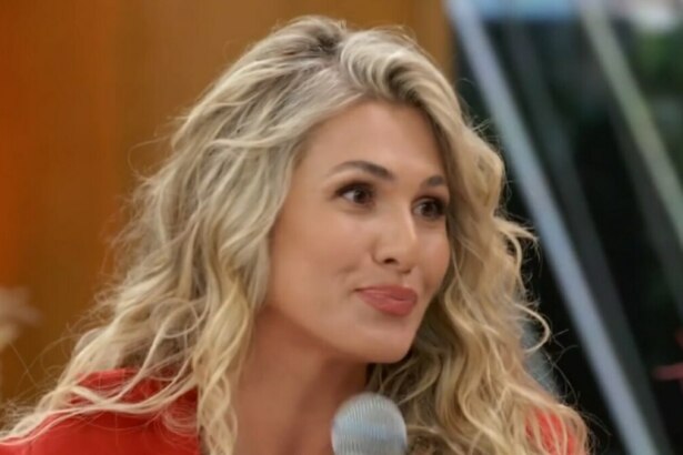 A apresentadora Lívia Andrade, de cabelos loiros e jaqueta vermelha, sorri em um close-up no programa 'Encontro'.