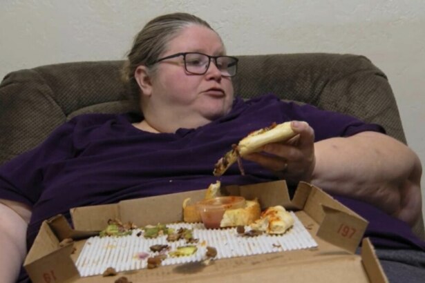 Mulher chamada Bethany, sentada em uma poltrona, segura um pedaço de pizza na mão. Ela está usando uma blusa roxa e óculos. Em seu colo, há uma caixa de pizza com restos de comida. O nome do arquivo a identifica como participante do programa 'Quilos Mortais'.