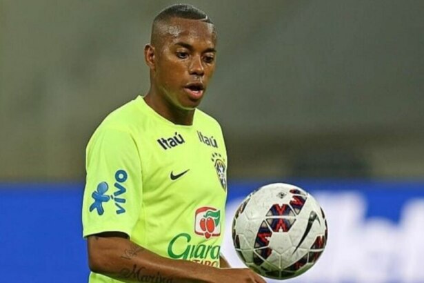Robinho, jogador de futebol da seleção brasileira, segurando uma bola de treino.