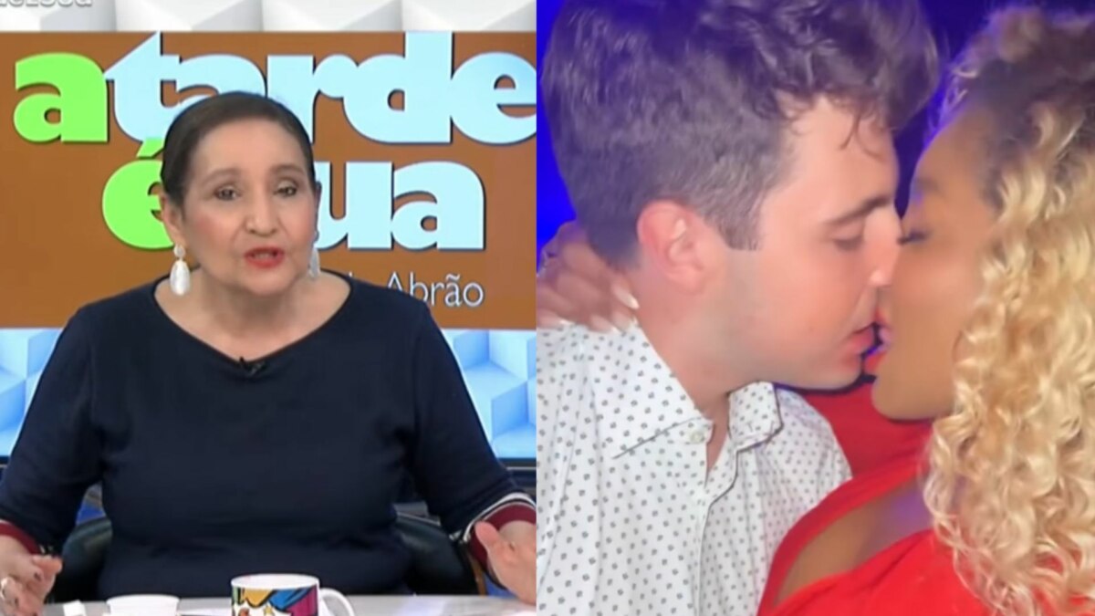 A imagem é uma montagem de duas fotos. Na foto da esquerda, a apresentadora Sônia Abrão está sentada em um estúdio de TV, com uma expressão séria enquanto fala. Ela usa uma blusa azul-marinho com detalhes vermelhos e grandes brincos brancos. Ao fundo, um painel com a inscrição "A TARDE É SUA". Na foto da direita, a mesma imagem da montagem anterior, em que o apresentador João Augusto Liberato e a apresentadora Cariúcha estão se beijando.