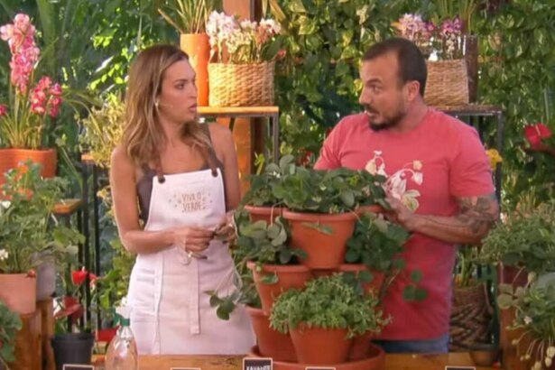 Talitha Morete e Murilo Soares no programa "É de Casa", com Talitha usando um avental e Murilo gesticulando em um cenário repleto de plantas.