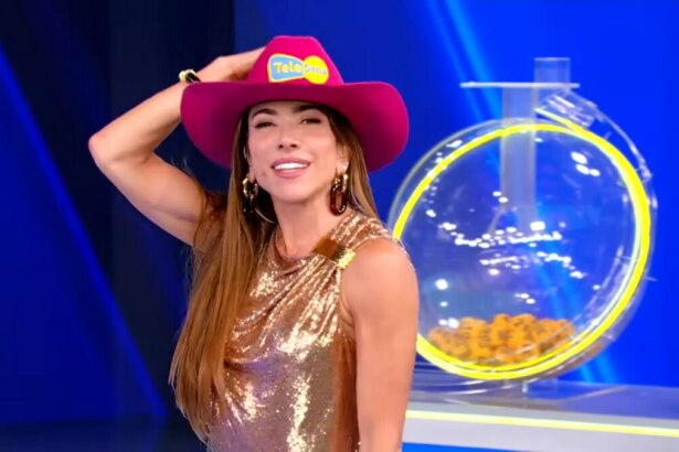 Patricia Abravanel segura chapéu rosa da Tele Sena da independência 2025 em frente a um globo do sorteio