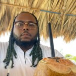 Travis, do Quilos Mortais, em momento descontraído, bebe água de coco e exibe visual atual após perder 109 kg