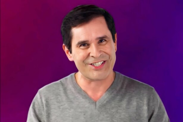 Apresentador Bob Floriano, sorrindo e olhando para a câmera, contra um fundo que varia do roxo ao magenta.