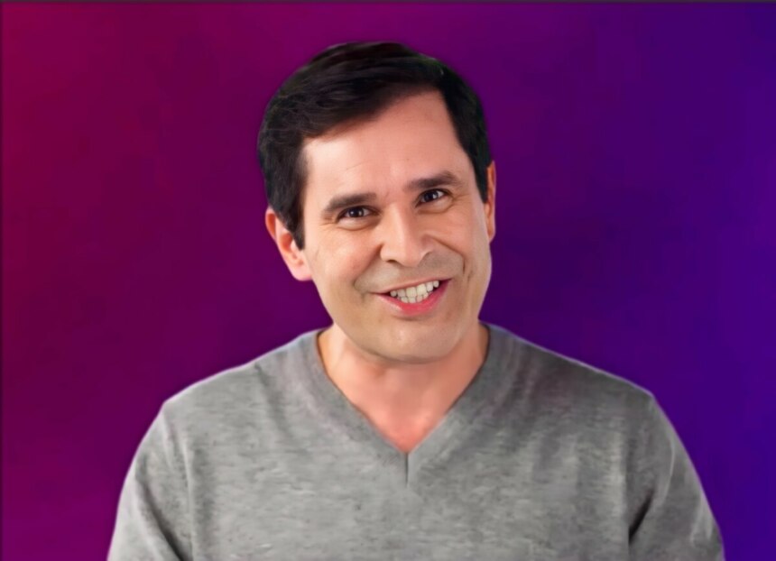Apresentador Bob Floriano, sorrindo e olhando para a câmera, contra um fundo que varia do roxo ao magenta.