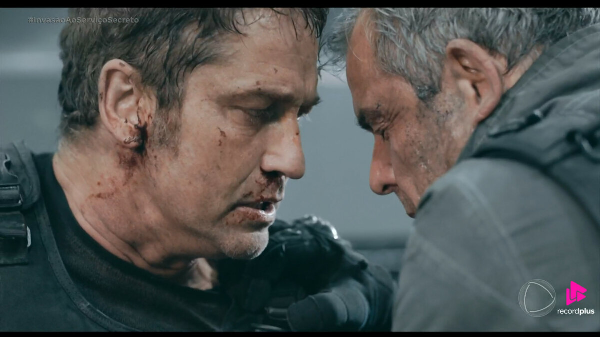 Protagonista do Filme Invasão ao Serviço Secreto olha para o rival que está todo ensanguentado em cena final do longa