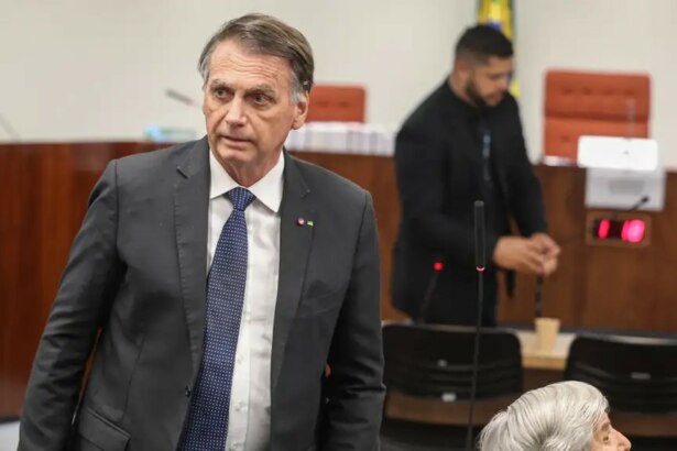 Jair Bolsonaro de terno preto e gravata azul olhando para o lado com semblante assustado