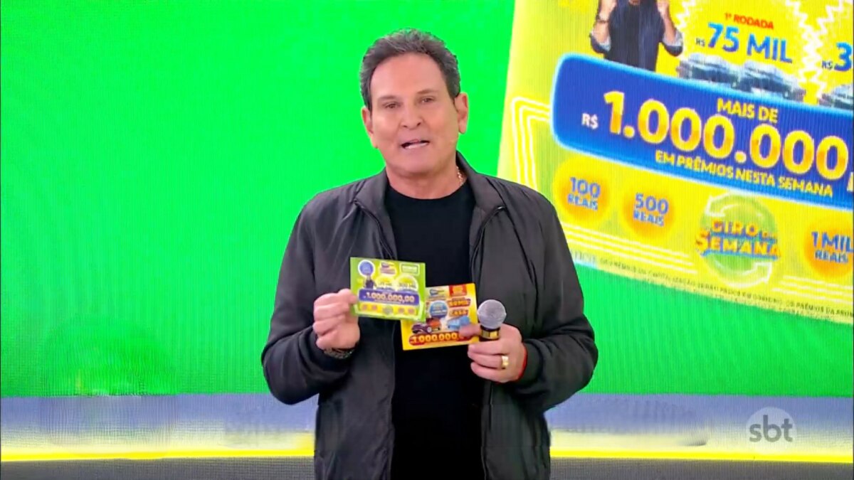Luis Ricardo segura o bilhete da Tele Sena Semanal edição 67, ao fundo um telão verde exibindo uma parte da Tele Sena