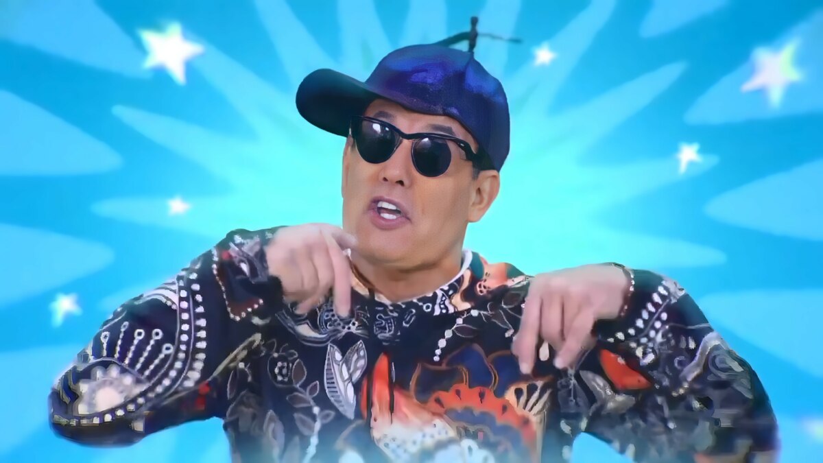 Sérgio Mallandro no comercial do Porta dos Desesperados, usando boné azul e camisa colorida diante de fundo azul vibrante
