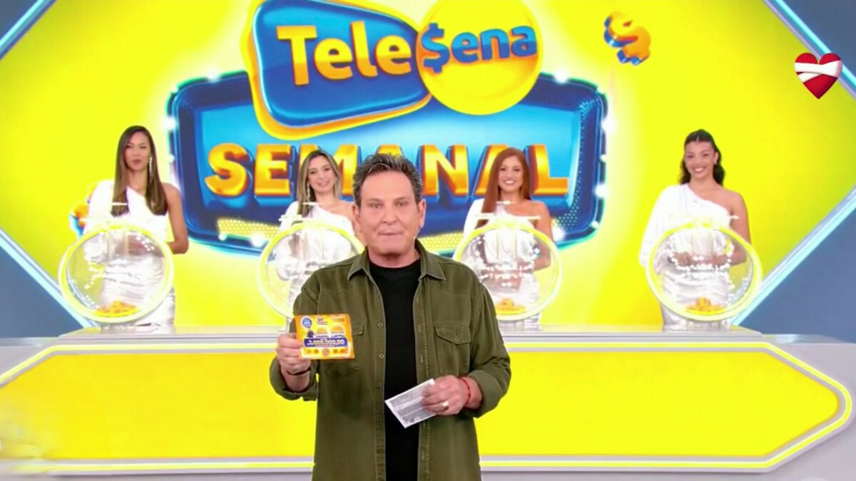 Apresentador Luis Ricardo no palco do SBT, exibindo uma Tele Sena Semanal, edição 65. Atrás dele, quatro mulheres em vestidos brancos seguram esferas de sorteio. O telão ao fundo diz "Tele Sena Semanal".