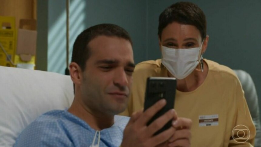 Afonso (Humberto Carrão), segurando um celular, e Celina (Malu Galli), em trecho de cena de Vale Tudo