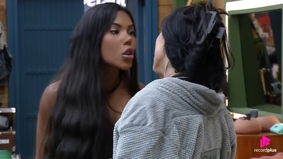 As participantes Rayane, de cabelos escuros e lisos, e Carol, de cabelos trançados, discutem de perto em uma cena do reality show A Fazenda. Rayane está falando em um tom confrontacional, enquanto Carol a encara.