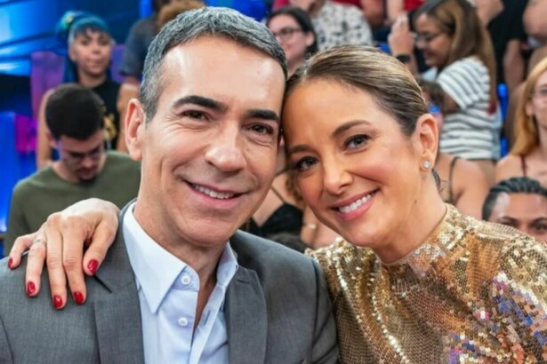 O jornalista Cesar Tralli e a apresentadora Ticiane Pinheiro sorriem juntos para uma foto em um estúdio de TV.
