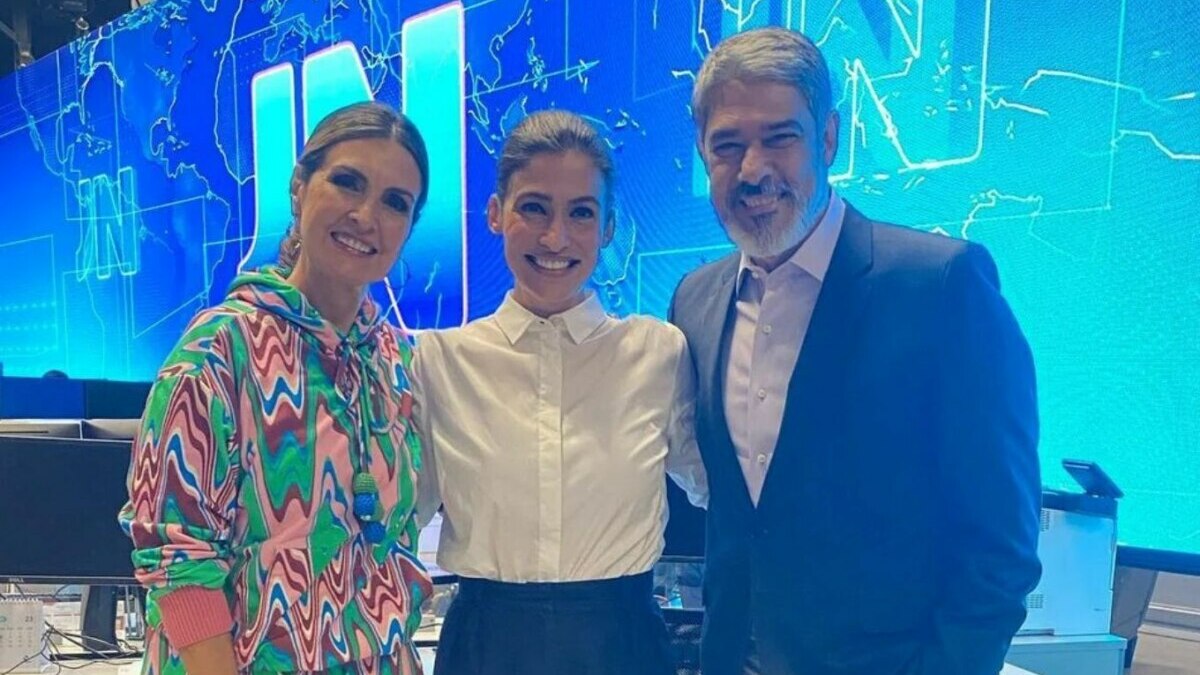 Fatima Bernardes, Renata Vasconcellos e William Bonner abraçados em foto posada nos bastidores do Jornal Nacional