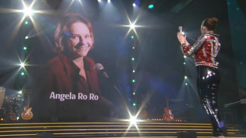 Angelo Ro Ro com imagem exposta no telão sendo aplaudida e homenageada no Estrela da Casa