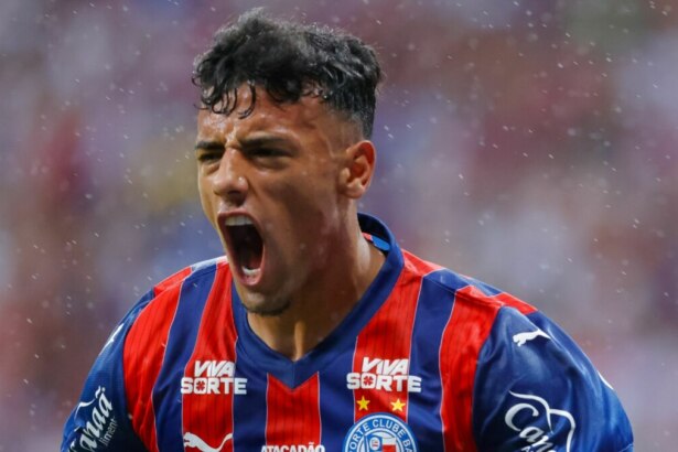 O jogador Lucho Rodríguez do Bahia, com a camisa do time, está no campo de futebol, gritando em comemoração e com o braço para cima durante a final da Copa do Nordeste.