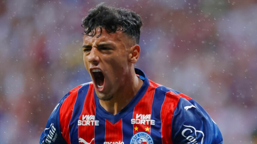 O jogador Lucho Rodríguez do Bahia, com a camisa do time, está no campo de futebol, gritando em comemoração e com o braço para cima durante a final da Copa do Nordeste.
