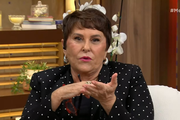 Marcia Sensitiva, com um blazer de bolinhas e brincos grandes, sorri e gesticula com as mãos, dando uma entrevista para o programa Melhor da Tarde.