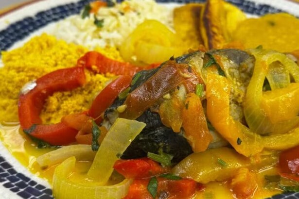 Moqueca de anchova da Talitha Morete bem temperada em cima de um prato branco no balcão do É De Casa