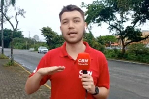 Repórter Niro Souza, com o uniforme da rádio CBN Joinville, em entrada ao vivo no Bom Dia SC