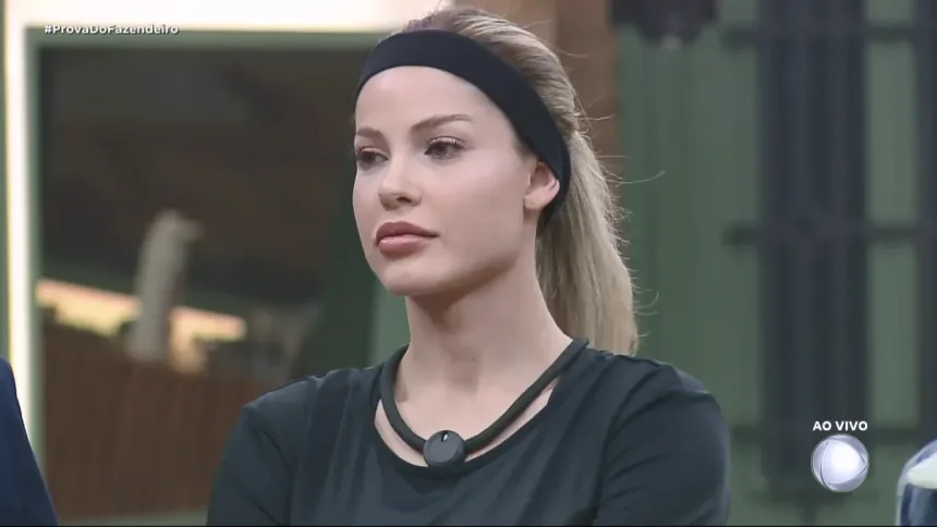 Saory Cardoso com faixa preta na cabeça em pé na sala de A Fazenda 17