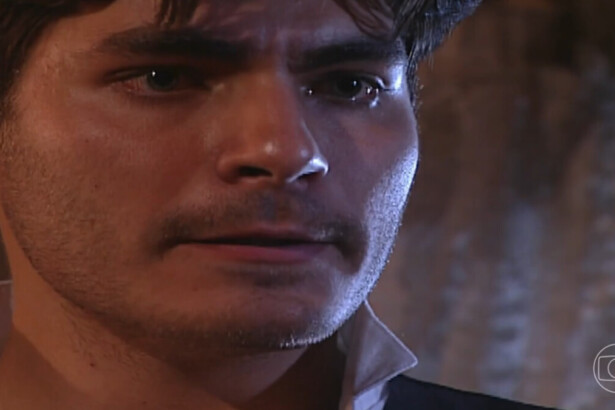 O ator Thiago Lacerda interpreta o personagem Matteo na novela Terra Nostra, com um close em seu rosto. Ele usa uma camisa branca de gola larga, tem um bigode fino e uma expressão séria e triste, com lágrimas nos olhos.