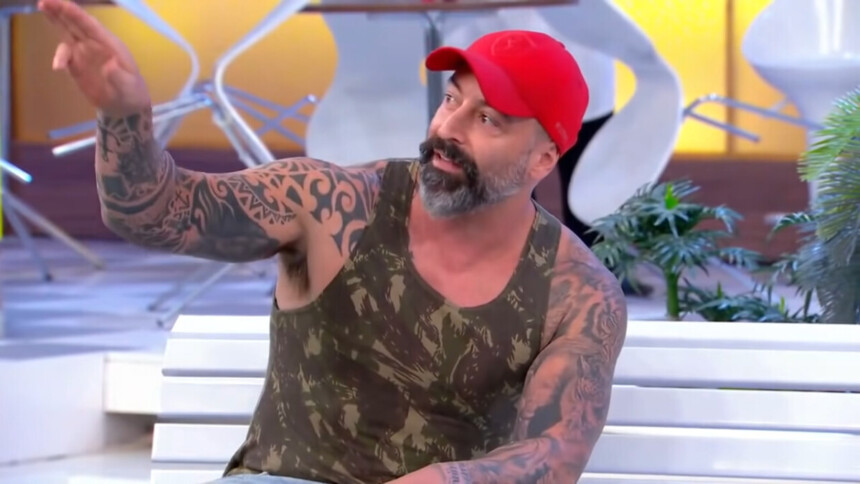 Cristiano Pereira de boné vermelho sentado no A Praça é Nossa do SBT